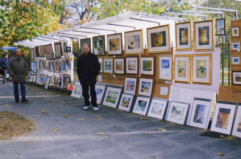 Bill Holkham at a UK outdoor art fair early in his career holding an aviation watercolor painting